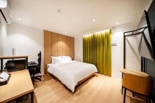 Dormitorio con cama, escritorio y TV en Hound Hotel Gumi indong, en Gumi