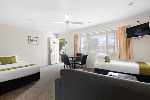 Habitación de hotel con 2 camas y sofá en Best Western BKs Pioneer Motor Lodge en Auckland