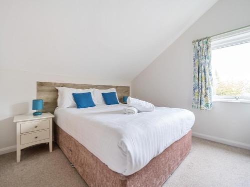 sypialnia z dużym łóżkiem i oknem w obiekcie Maple - Woodland Cottages w mieście Bowness-on-Windermere