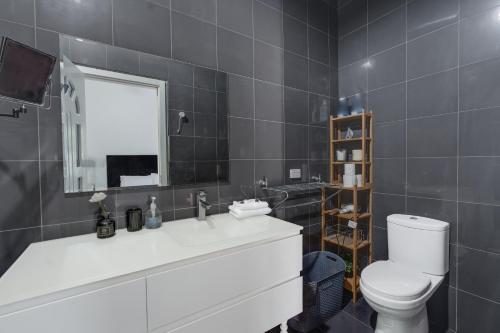 W łazience znajduje się toaleta, umywalka i lustro. w obiekcie Hope Island Haven Retreat w mieście Gold Coast