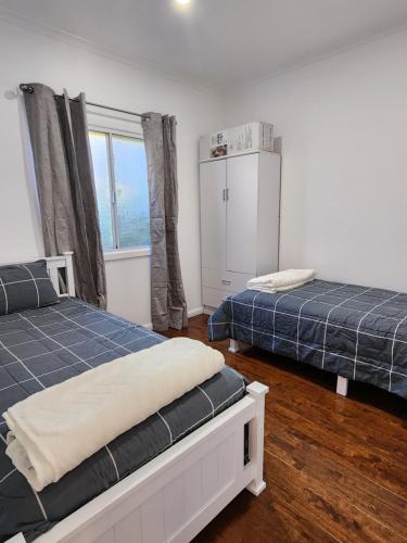 1 dormitorio con 2 camas y ventana en LUXURIOUS Couples Escape, SPA BATH, Netflix, NBN, en Victor Harbor