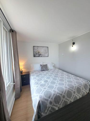a bedroom with a bed and a window at Habitations Zenith in Sainte-Anne-de-Beaupré
