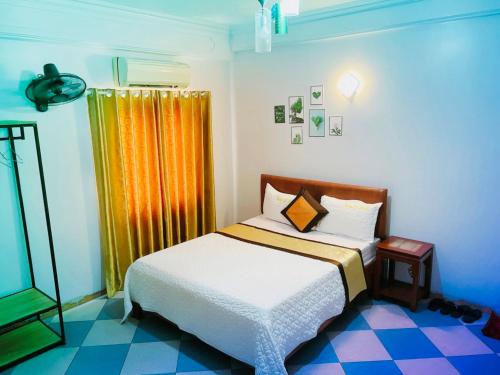 een slaapkamer met een bed en een geel gordijn bij Thắng Lợi Hotel in Thanh Hóa