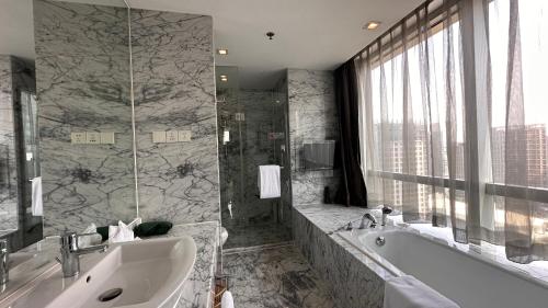 un ampio bagno con vasca e lavandino di Holiday Inn Xi'an Greenland Century City, an IHG Hotel a Xi'an