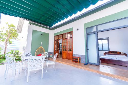 a patio with a table and chairs and a room at Nine Homestay in Can Tho