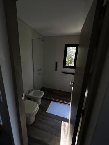 a small bathroom with a toilet and a sink at Casa Raíz Cumbrecita in La Cumbrecita