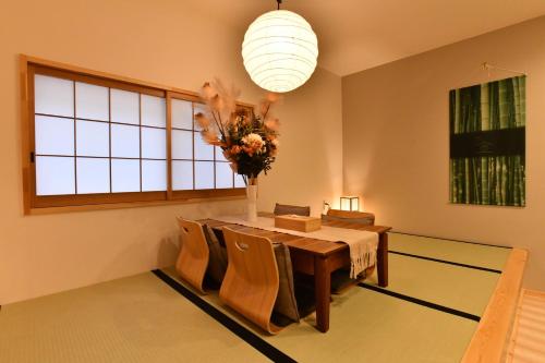 une salle à manger avec une table et un vase de fleurs dans l'établissement FL House 浪花町, à Osaka