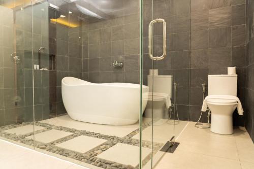 a bathroom with a tub and a toilet at Altaroca Mountain Resort Antipolo in Antipolo