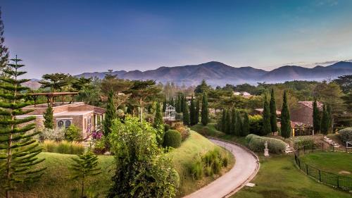a house with a road leading to a garden at La Toscana in Suan Phung