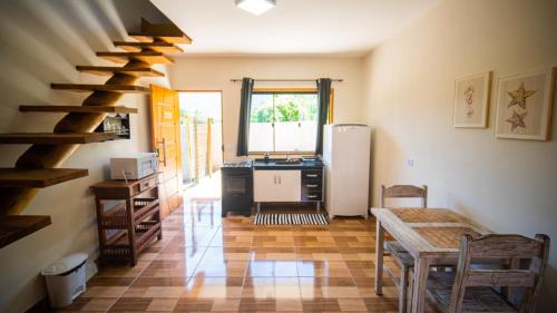 cocina con escalera, mesa y nevera en Chalés Oliveira, en Ilhabela