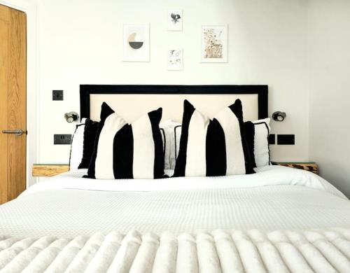 a bedroom with a white bed with black and white pillows at Newly Renovated Gem - Free Parking & Modern Comfort in Glasgow