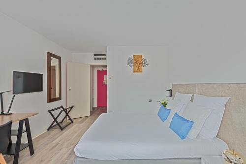 a living room with a white bed and a table at Hôtel Provence in Draguignan