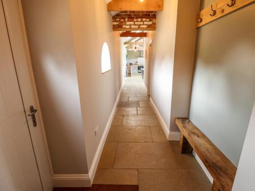 a hallway with a tile floor and a bench at Little Owl in Market Rasen