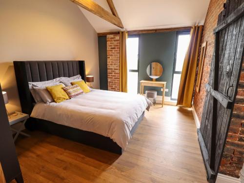 a bedroom with a bed and a brick wall at Little Owl in Market Rasen