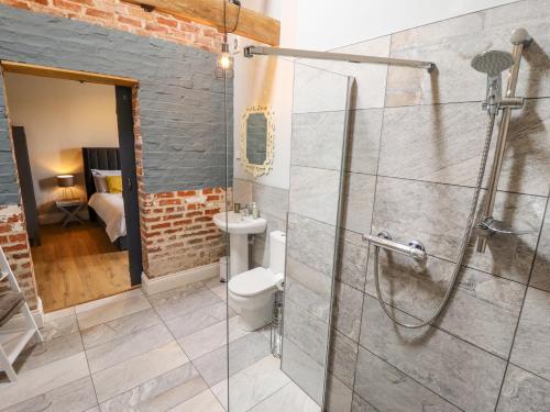 a bathroom with a shower and a toilet and a sink at Little Owl in Market Rasen