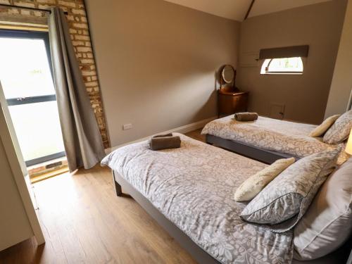 a bedroom with two beds and a window at Little Owl in Market Rasen