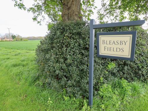 a sign in front of a bush with a signergy fields at Little Owl in Market Rasen