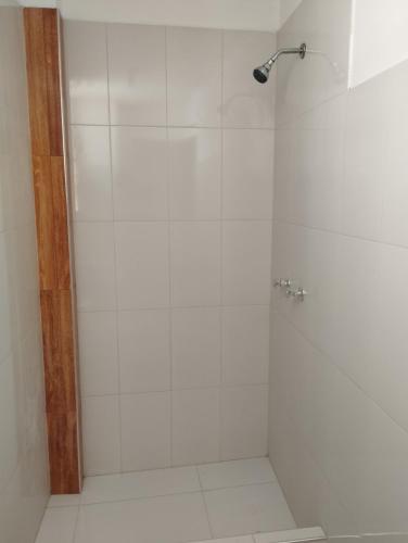 a bathroom with a shower with white tile at Alpha in Cajamarca
