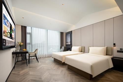 a hotel room with two beds and a flat screen tv at Atour Hotel Ningbo Cixi Ancient Town in Ningbo