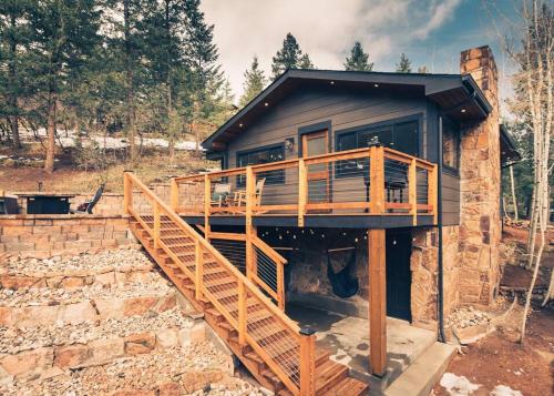 a house with a staircase leading up to it at Modern Luxury Cabin - Hot Tub, Hiking, Hammocks in Cascade-Chipita Park