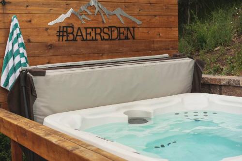 a hot tub in a backyard with a sign on a wooden wall at Modern Luxury Cabin - Hot Tub, Hiking, Hammocks in Cascade-Chipita Park