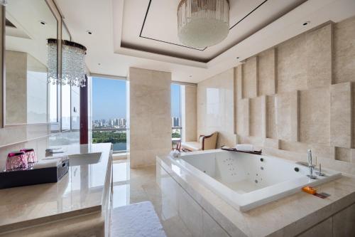 baño grande con bañera y ventana grande en Sheraton Changde Wuling Hotel en Changde