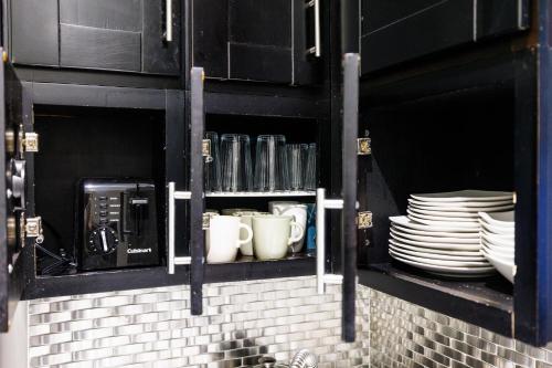 a black cabinet with plates and cups and coffee cups at Park Side Living, City Style in New York