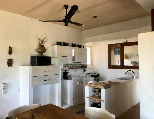 a kitchen with white cabinets and a ceiling fan at La Candelaria in Dibulla