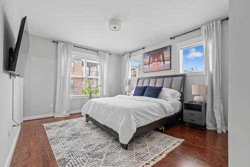 a white bedroom with a bed and two windows at Richmond Gem, Free Parking, Quiet, Fenced,Walkable in Richmond