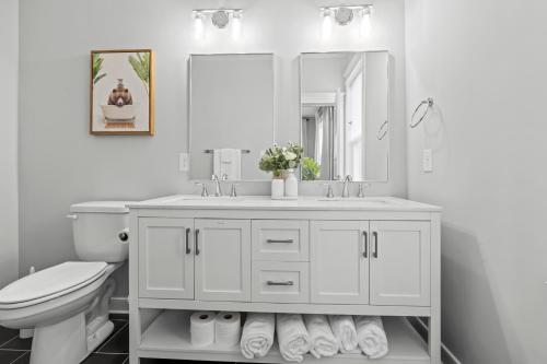 a bathroom with a sink and a toilet and a mirror at Richmond Gem, Free Parking, Quiet, Fenced,Walkable in Richmond