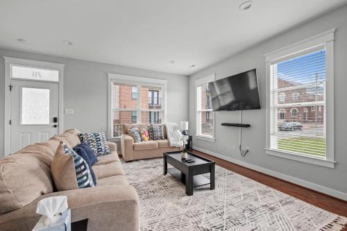 a living room with a couch and a tv at Richmond Gem, Free Parking, Quiet, Fenced,Walkable in Richmond