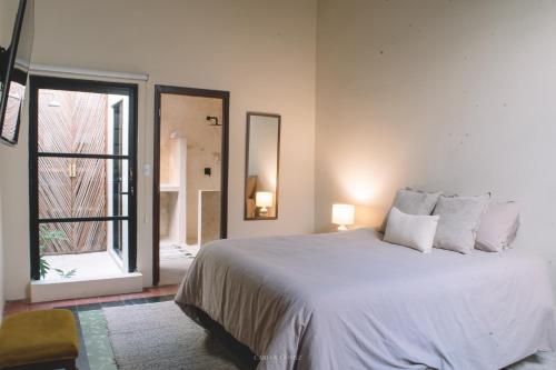 a bedroom with a large white bed and a window at Casa Alicia @ Downtown in Mazatlán