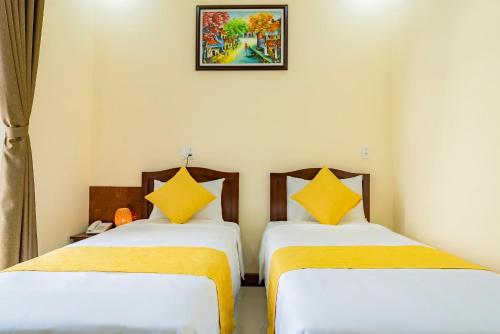 two beds sitting next to each other in a room at Green Hill Hotel in Hoi An