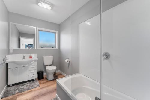 a bathroom with a shower and a sink and a toilet at Motuoapa Getaway - Lake Taupo Holiday Home in Turangi