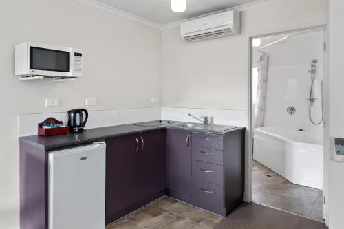 ein Badezimmer mit einem Waschbecken und einer Badewanne in der Unterkunft Best Western BKs Pioneer Motor Lodge in Auckland