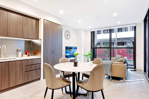 una cucina e una sala da pranzo con tavolo e sedie di Comfy 1 Bedroom in Homebush a Sydney