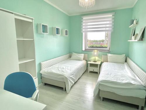 een slaapkamer met 2 bedden en een raam bij Apartament Karczyn - noclegi dla miłośników natury i spokoju in Karczy