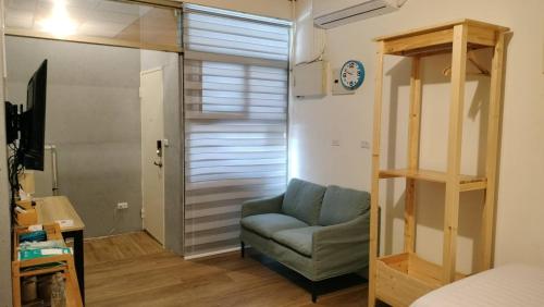 a living room with a couch and a clock on the wall at 水源棧 in Fengyuan