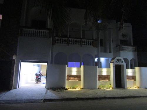 a building with a person on a motorcycle in front of it at night at Villa Dakar 200 m plage in Dakar