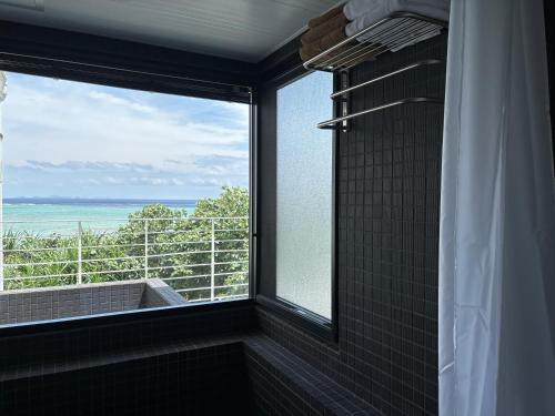 Baño con ventana con vistas al océano en CASA DUMAI OceanVilla NAKIJIN, en Nakijin