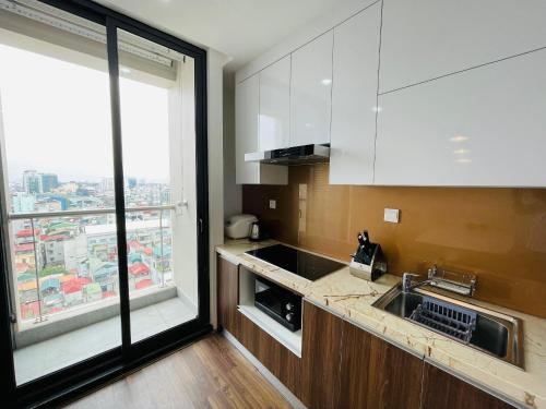 a kitchen with a sink and a large window at Nesta - The Grand Hao Nam in Hanoi
