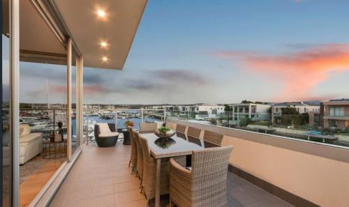 a balcony with a table and chairs and a view of a harbor at The Ultimate View! in Safety Beach