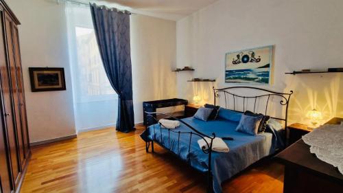 ein Schlafzimmer mit einem blauen Bett in einem Zimmer in der Unterkunft La Casa di Geo Stazione Centrale La Spezia 5 Terre in La Spezia