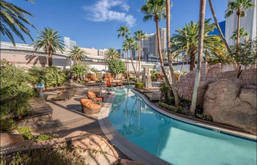 a swimming pool at a resort with palm trees at Jewel Suite w/balcony MGM SIGNATURE * 23rd FLOOR* STRIP VIEW in Las Vegas