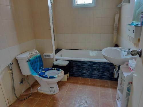 La salle de bains est pourvue de toilettes, d'une baignoire et d'un lavabo. dans l'établissement Friend's House, à Bangkok
