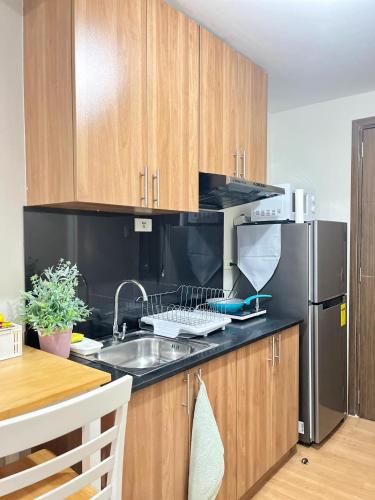 a kitchen with a sink and a refrigerator at 21st floor The Loop Condo Studio in Cagayan de Oro City Lucky 14 in Cagayan de Oro