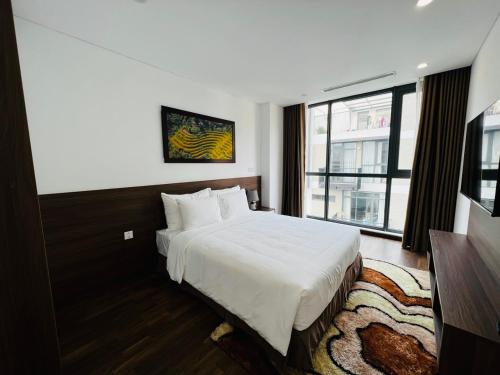 a hotel room with a bed and a window at Nesta - The Grand Hao Nam in Hanoi