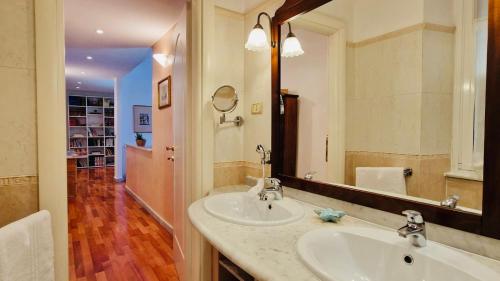 ein Badezimmer mit zwei Waschbecken und einem großen Spiegel in der Unterkunft La Casa di Geo Stazione Centrale La Spezia 5 Terre in La Spezia