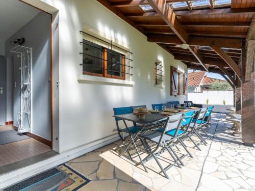 une salle à manger avec une table et des chaises sur un patio dans l'établissement Maison rénovée 6 pers. à Biscarrosse - Clim, jardin, à proximité du lac & plages - FR-1-319-549, à Biscarrosse