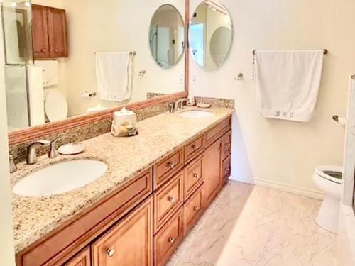a bathroom with two sinks and two mirrors at Beysicair Vacation Homes in Calabasas